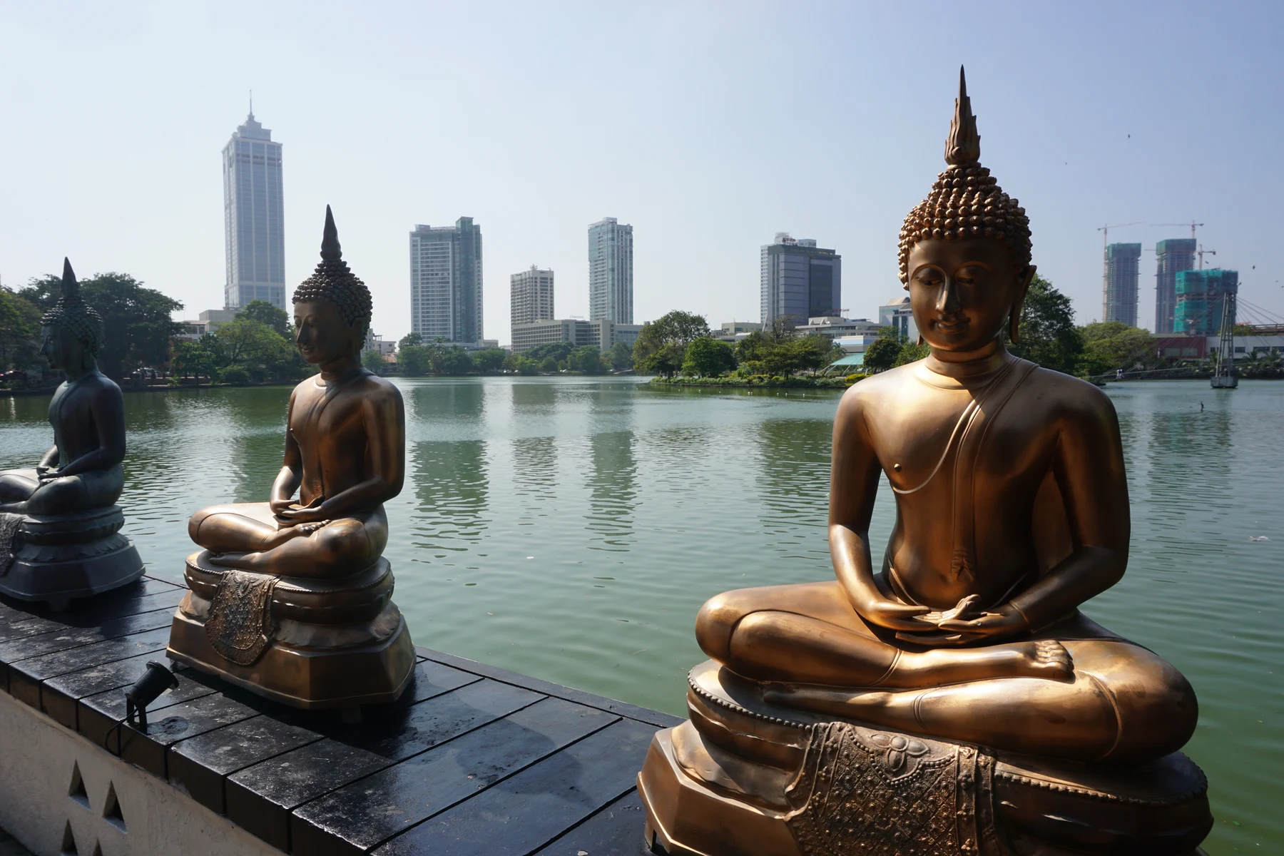 Seema Malaka statues and Colombo buildings across Beira Lake, photographed in 2017
